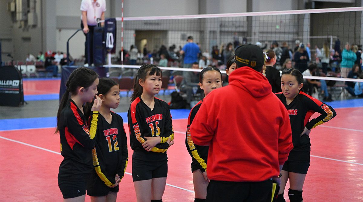 A coach talks to a group of athletes during a timeout
